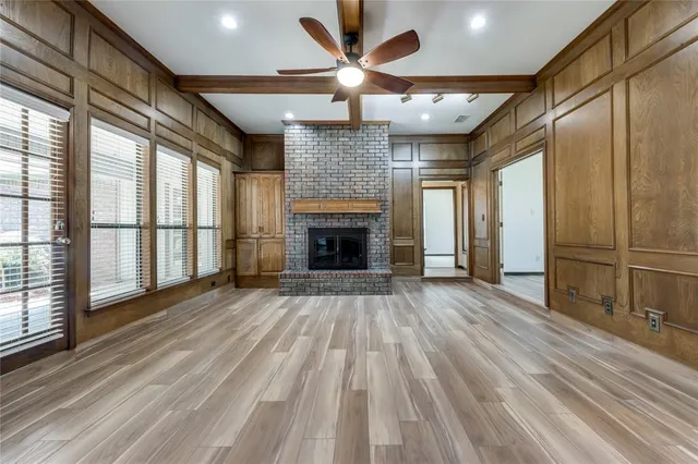 a view of empty room with wooden floor and fireplace
