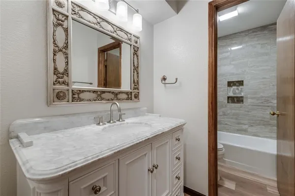 a bathroom with a granite countertop sink and a mirror