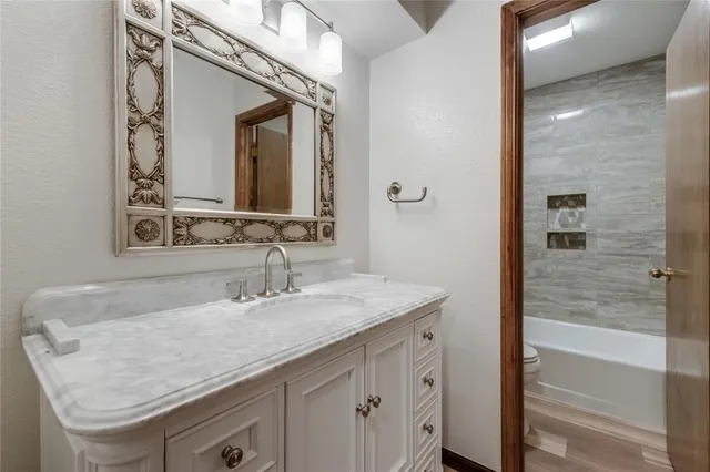 a bathroom with a granite countertop sink and a mirror