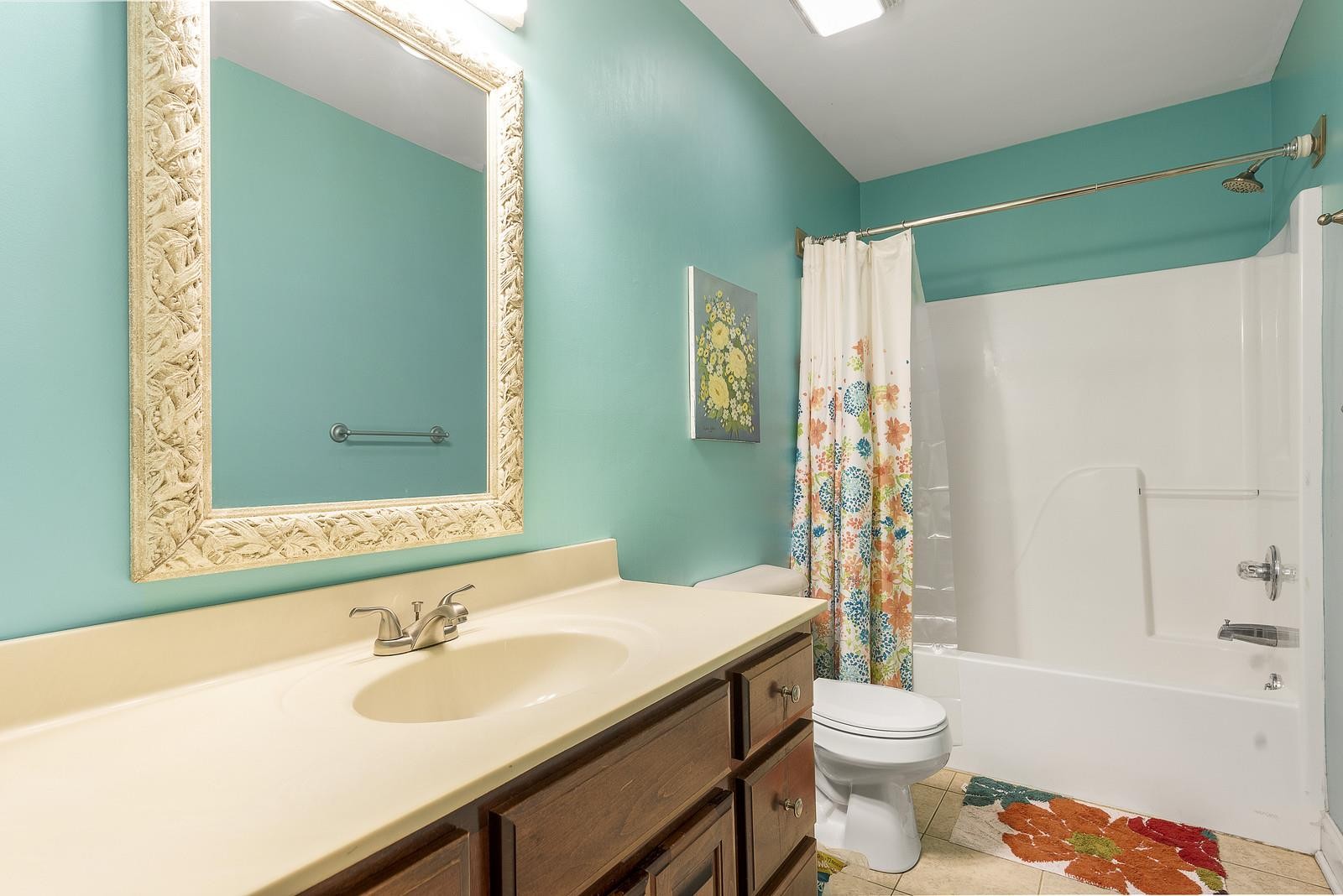 7205 Highland Road Portland, TN 37148 - Photo 17 of 29 a bathroom with a granite countertop sink toilet mirror vanity and shower