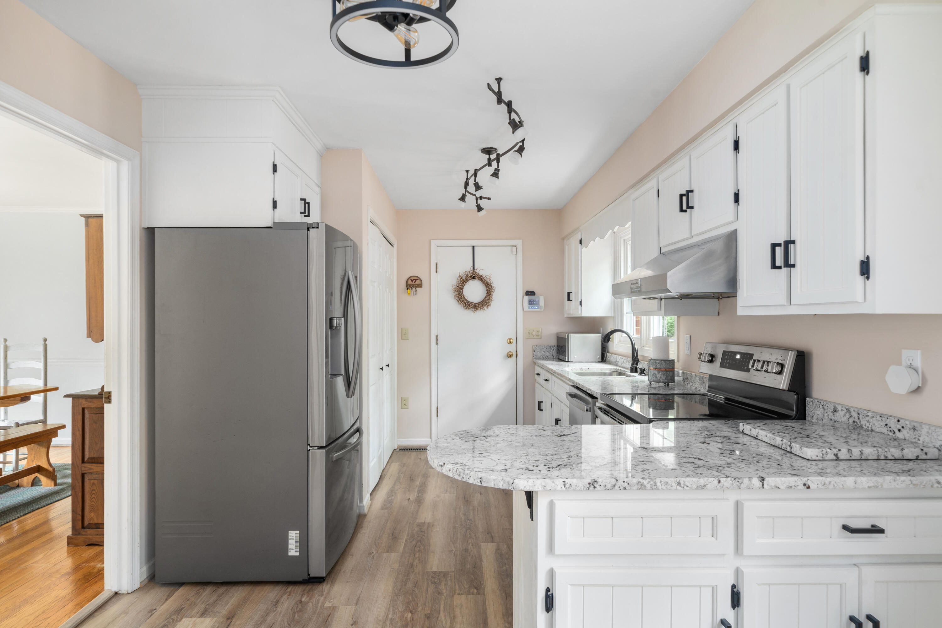 3341 Hidden Oak Road Southwest Roanoke, VA 24018 - Photo 15 of 26 a kitchen with stainless steel appliances granite countertop a refrigerator a sink dishwasher and white cabinets with wooden floor