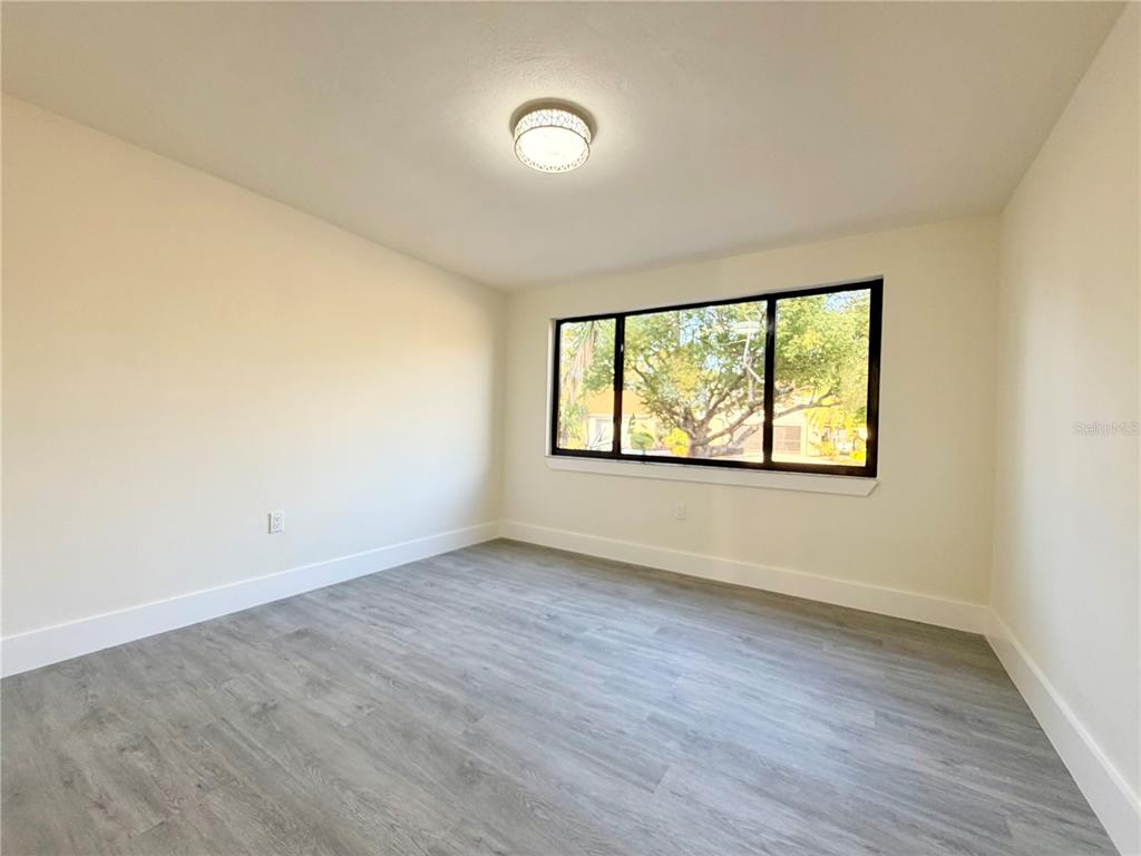 7314 Patio Row Hudson, FL 34667 - Photo 11 of 17 an empty room with wooden floor and windows