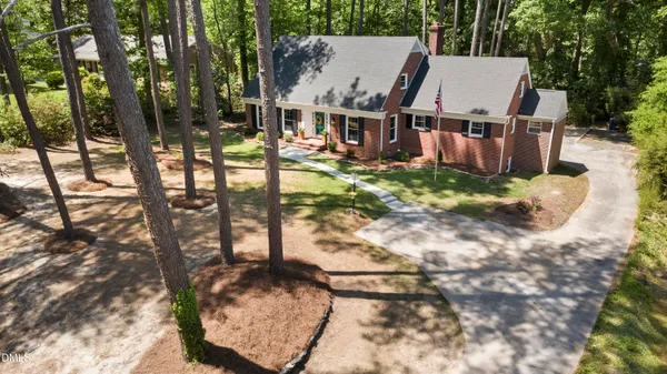 a view of a house with backyard and sitting area