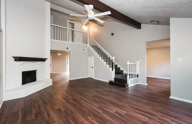 a view of a livingroom with wooden floor and a fireplace