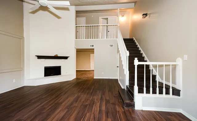 a view of a livingroom with wooden floor and staircase