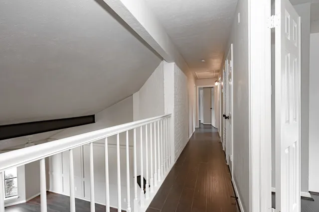 a view of a hallway with wooden floor and door