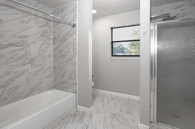 a bathroom with a bathtub and shower