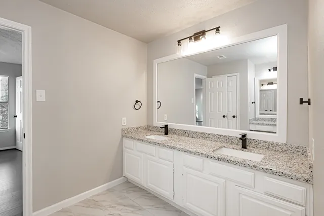 a bathroom with a granite countertop sink and a mirror