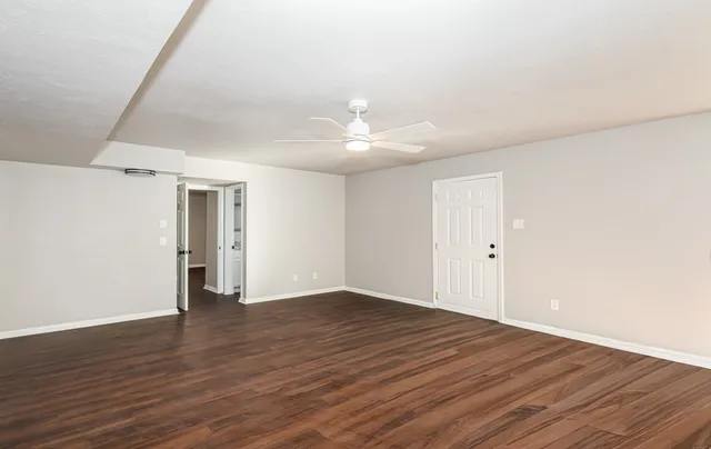 a view of an empty room with wooden floor