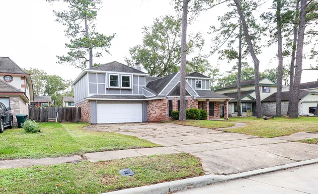 a front view of a house with a yard and trees