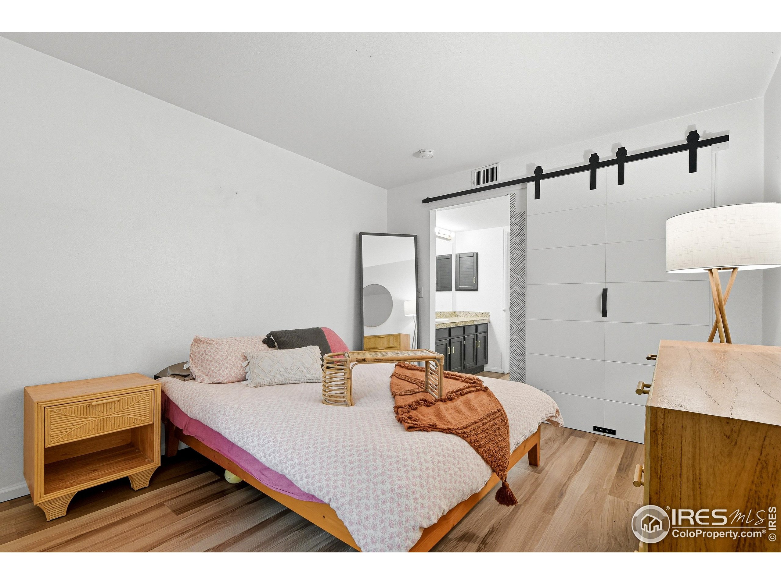 935 Broadway, Unit 104 Boulder, CO 80302 - Photo 11 of 21 a bedroom with a bed and wooden floor