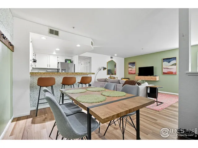 a living room with furniture a flat screen tv and a table