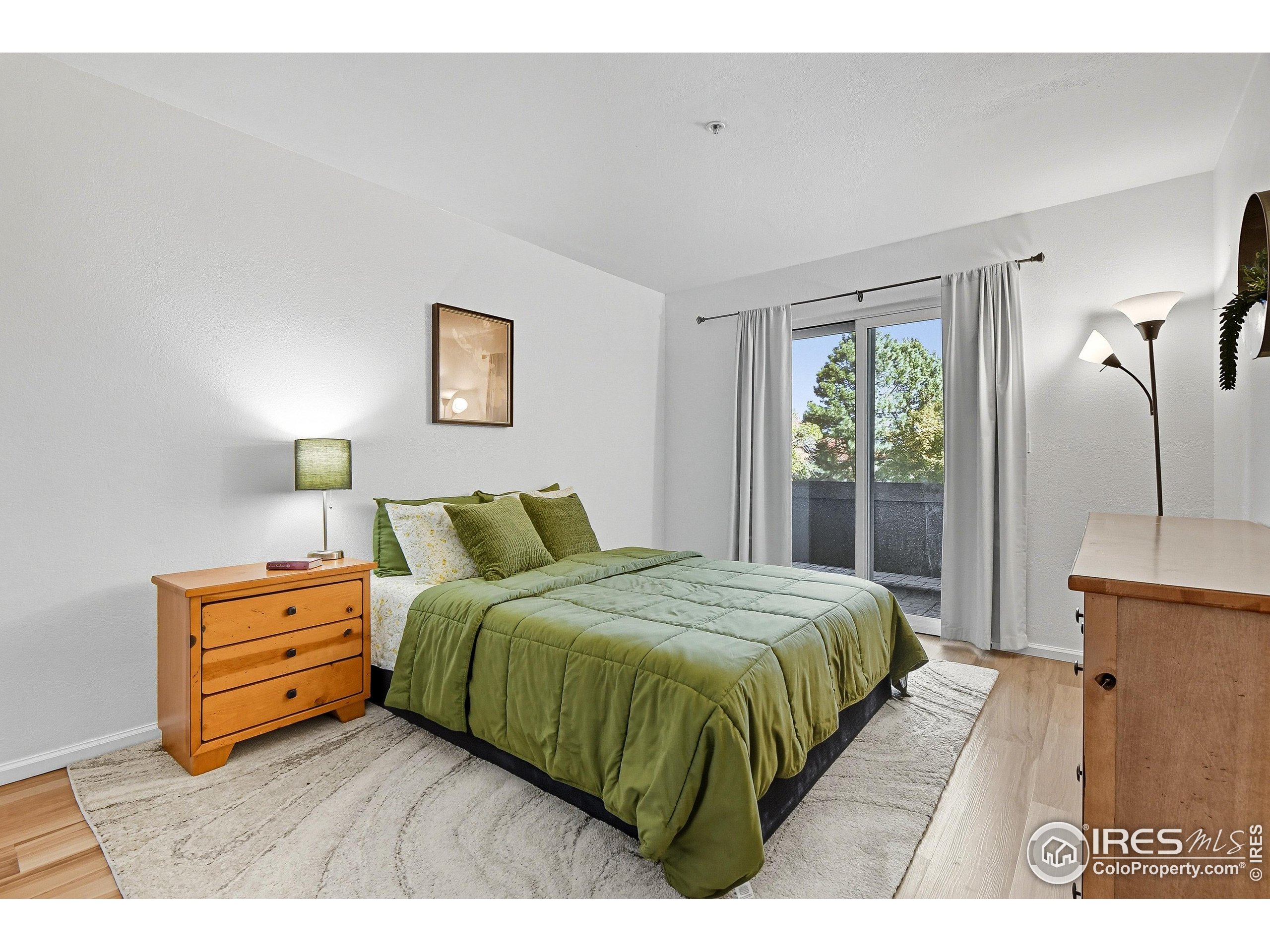 935 Broadway, Unit 104 Boulder, CO 80302 - Photo 9 of 21 a bedroom with a bed and a night stand