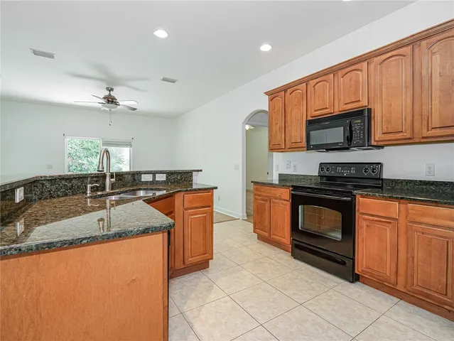 a kitchen with granite countertop a sink stainless steel appliances and cabinets