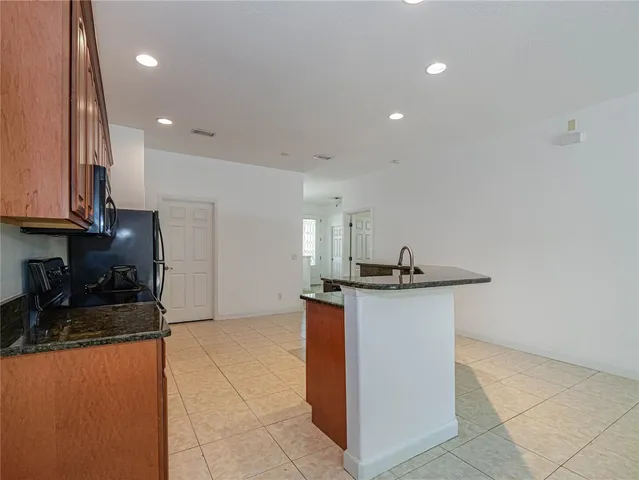 a kitchen with stainless steel appliances granite countertop a sink a stove a refrigerator and a refrigerator