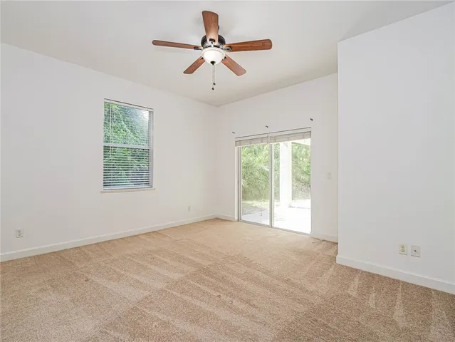 an empty room with fan and windows