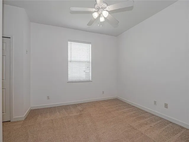 an empty room with a chandelier fan