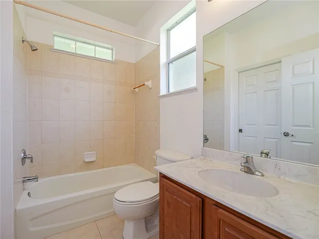 a bathroom with a granite countertop sink a toilet and shower