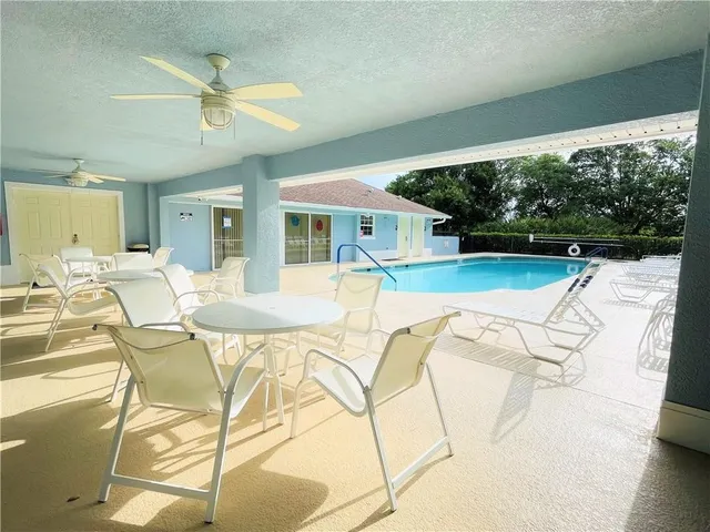 a view of a swimming pool and lounge chairs in the patio