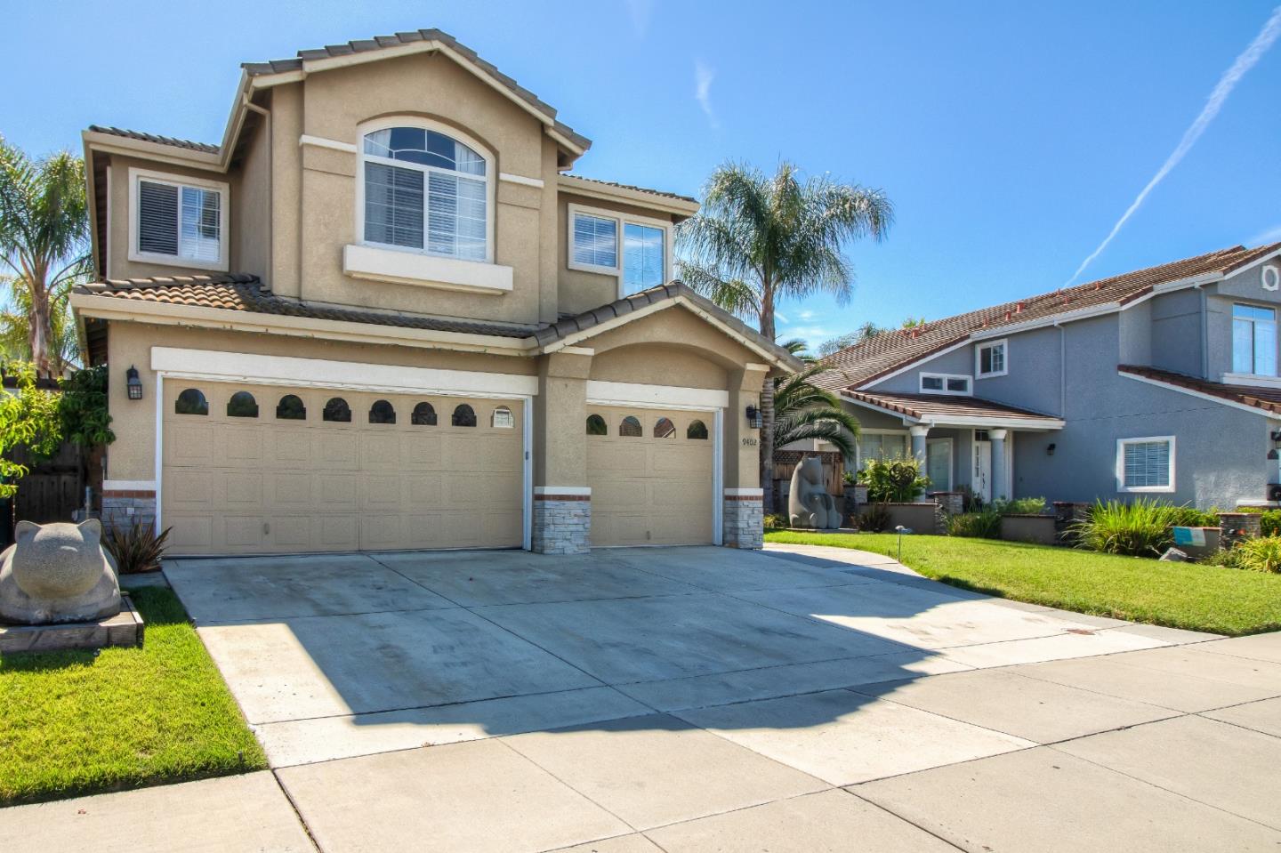 a front view of a house with a garden and trees