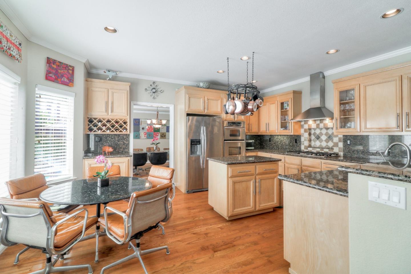 9402 Rodeo Drive Gilroy, CA 95020 - Photo 13 of 39 a kitchen with stainless steel appliances kitchen island granite countertop a dining table chairs and a refrigerator