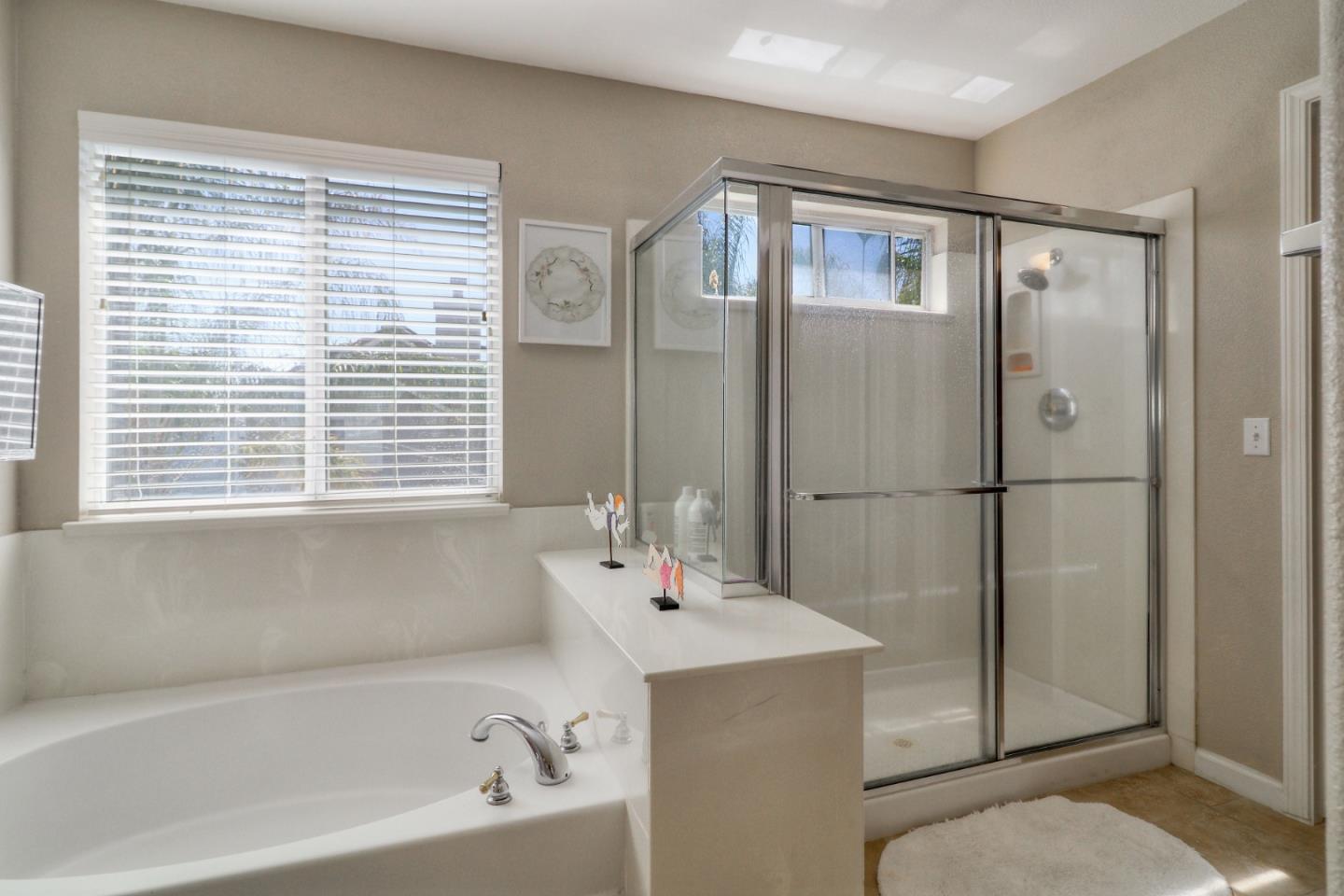 9402 Rodeo Drive Gilroy, CA 95020 - Photo 29 of 39 a bathroom with a bathtub a shower a sink and a window