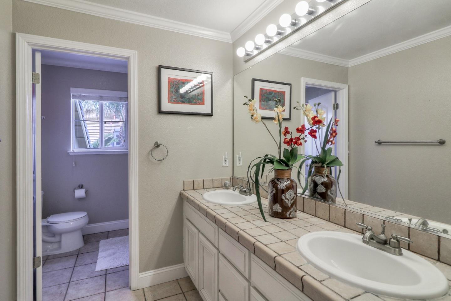 9402 Rodeo Drive Gilroy, CA 95020 - Photo 30 of 39 a bathroom with a granite countertop sink a toilet and a mirror
