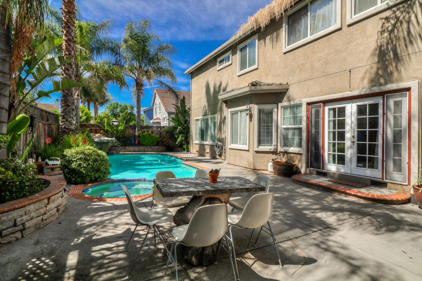 9402 Rodeo Drive Gilroy, CA 95020 - Photo 35 of 39 a view of a patio with table and chairs potted plants and floor to ceiling window and potted plants