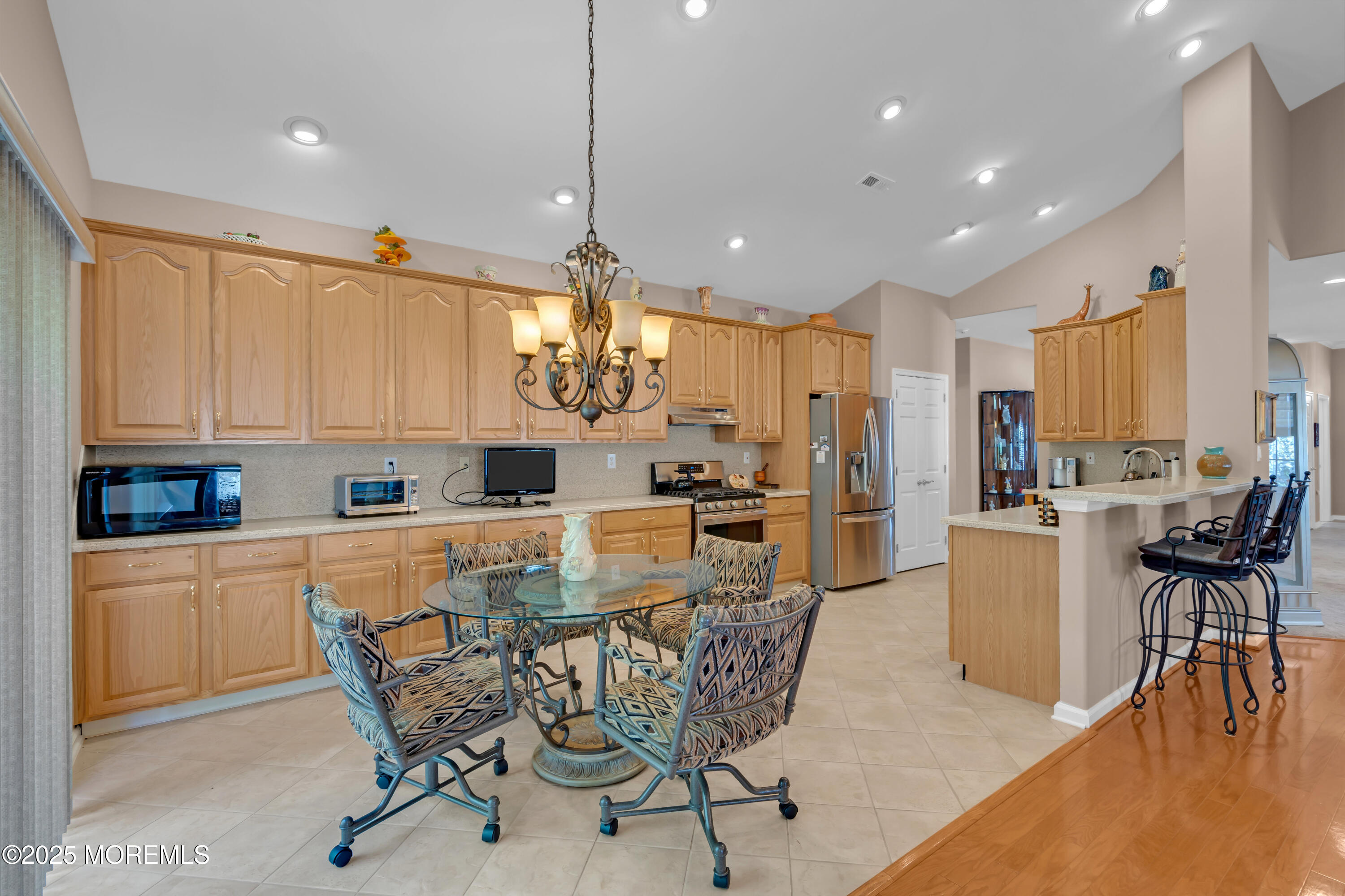 60 Eleanor Road Manchester Township, NJ 08759 - Photo 27 of 45 a kitchen with stainless steel appliances kitchen island granite countertop a table chairs and a refrigerator