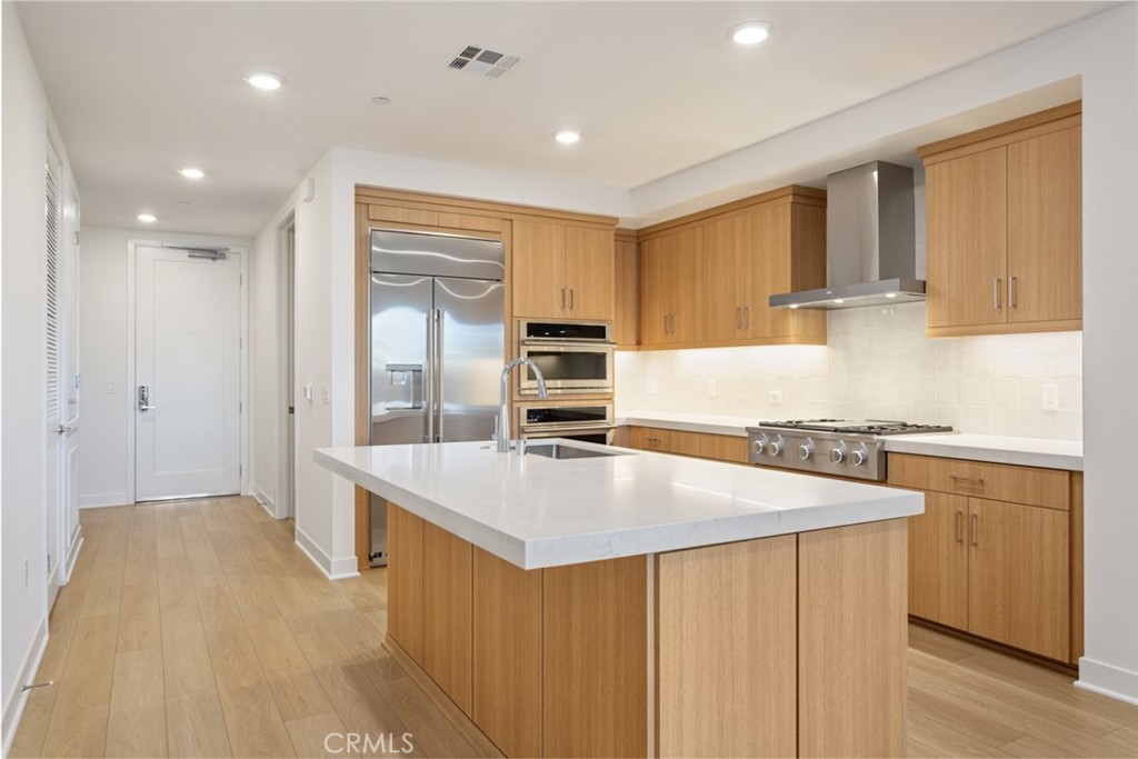 a kitchen with stainless steel appliances granite countertop a sink stove and refrigerator