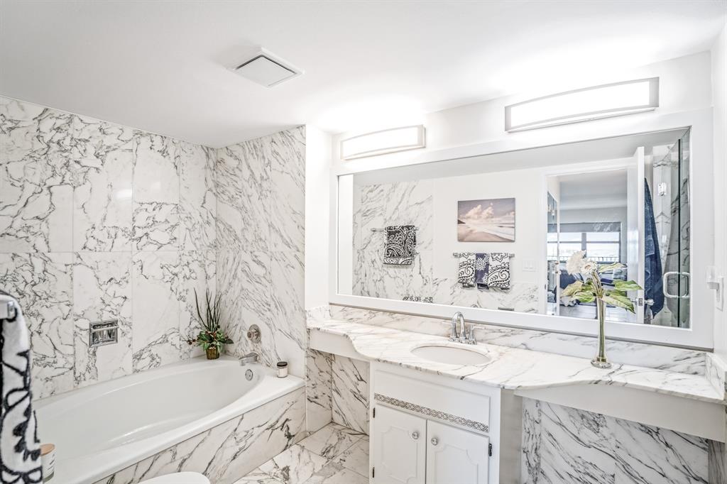 5100 North Ocean Boulevard, Unit 1217 Lauderdale-by-the-Sea, FL 33308 - Photo 13 of 32 a bathroom with a granite countertop sink and a bathtub