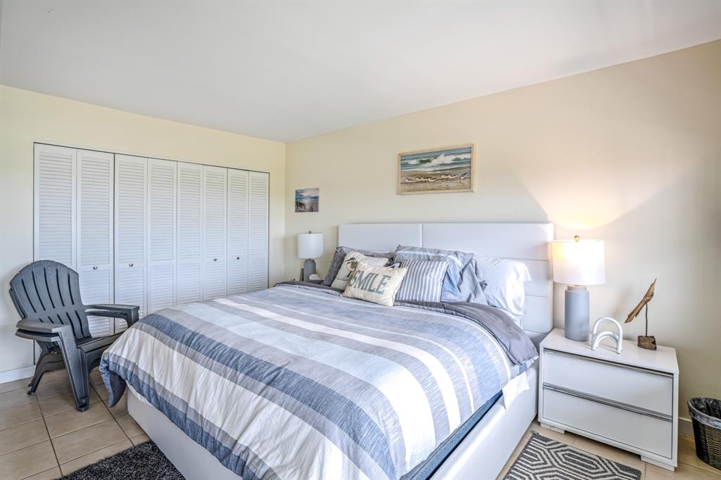 5100 North Ocean Boulevard, Unit 1217 Lauderdale-by-the-Sea, FL 33308 - Photo 17 of 32 a bedroom with a bed and a chair