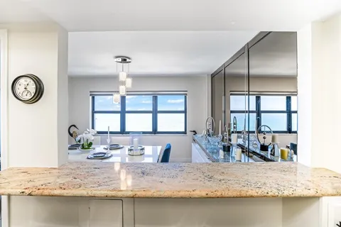 a kitchen with granite countertop a sink stove and cabinets