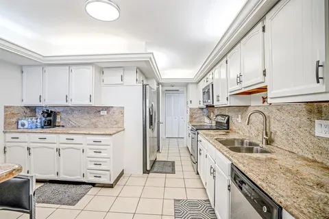 a kitchen with granite countertop a sink stove and cabinets