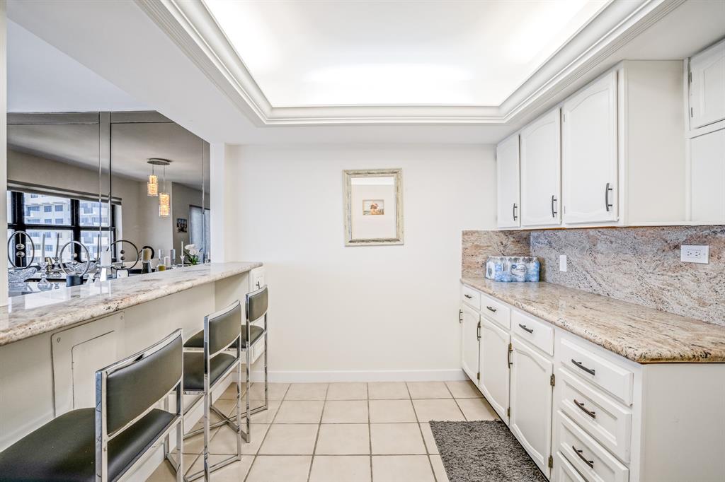 5100 North Ocean Boulevard, Unit 1217 Lauderdale-by-the-Sea, FL 33308 - Photo 6 of 32 a kitchen with granite countertop white cabinets and white appliances