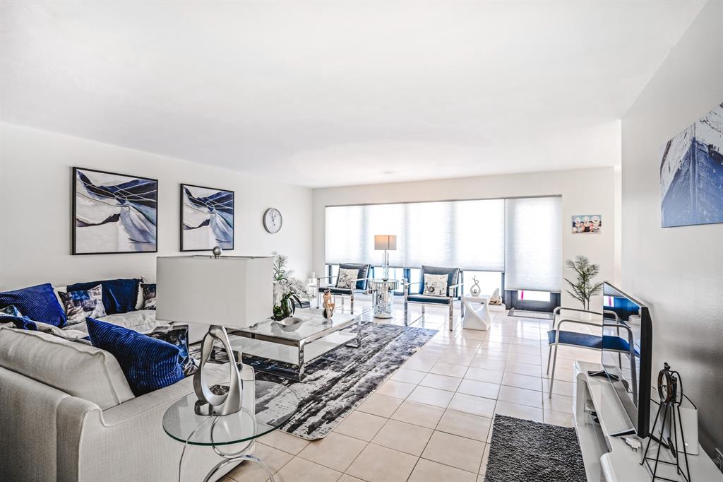 5100 North Ocean Boulevard, Unit 1217 Lauderdale-by-the-Sea, FL 33308 - Photo 8 of 32 a living room with furniture or couch and a dining table with kitchen view
