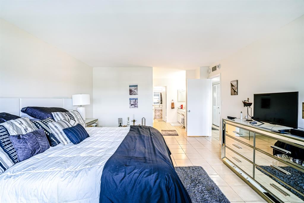 5100 North Ocean Boulevard, Unit 1217 Lauderdale-by-the-Sea, FL 33308 - Photo 10 of 32 a spacious bedroom with a bed and a flat screen tv