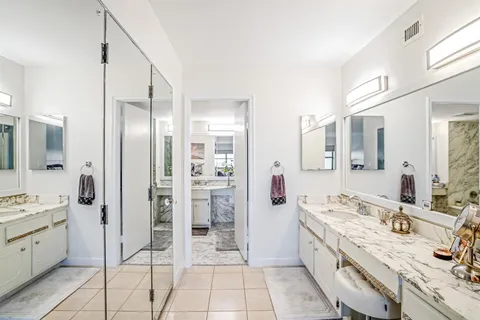 a spacious bathroom with a double vanity sink a mirror and shower