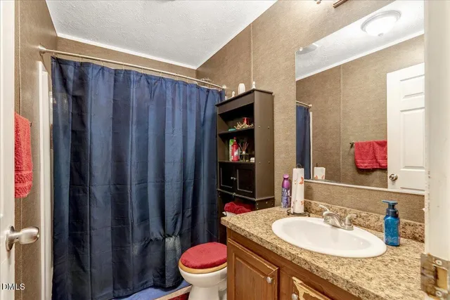 a bathroom with a granite countertop toilet sink and mirror