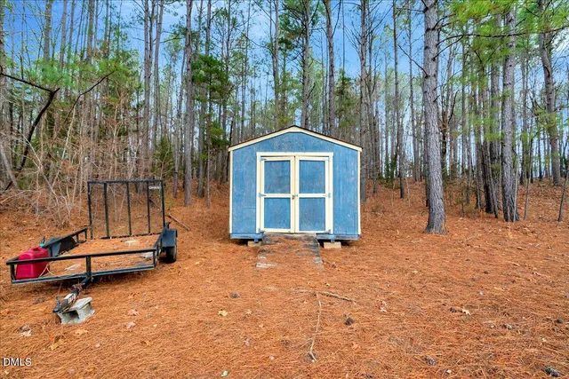 a view of a house with backyard and trees