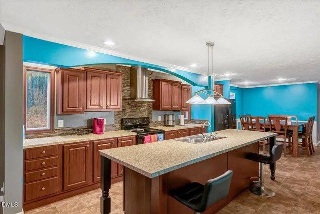 a kitchen with a stove a sink a dining table and chairs