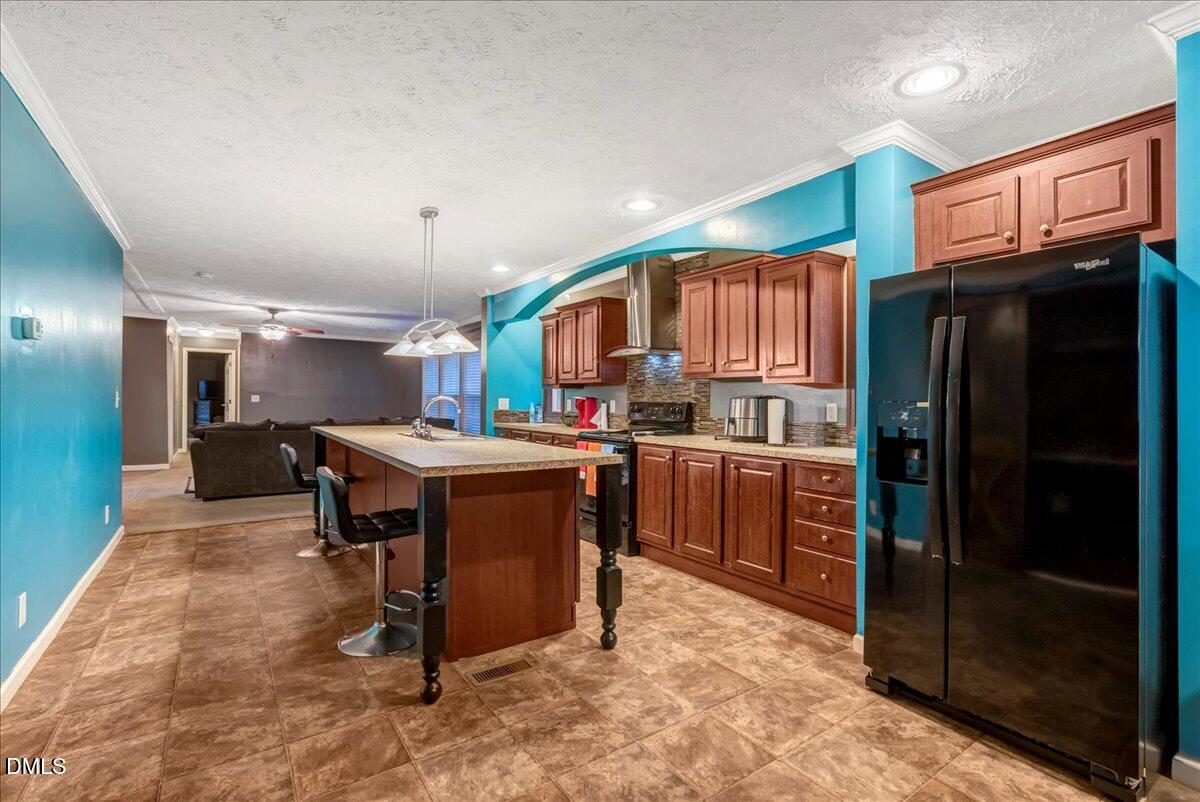 1779 Wise-Five Forks Road Macon, NC 27551 - Photo 9 of 23 a kitchen with stainless steel appliances kitchen island granite countertop a refrigerator and a stove top oven