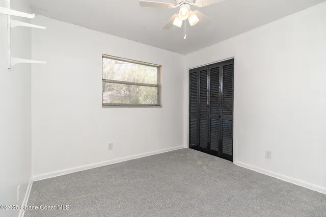 an empty room with a chandelier fan