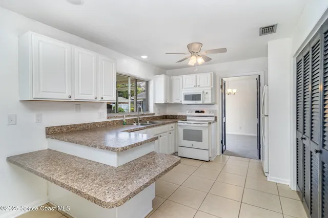 a kitchen with kitchen island granite countertop a stove sink and cabinets