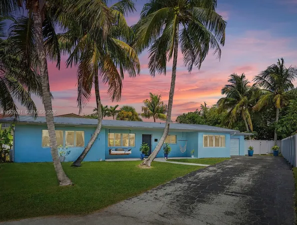 a front view of a house with a yard and palm tree