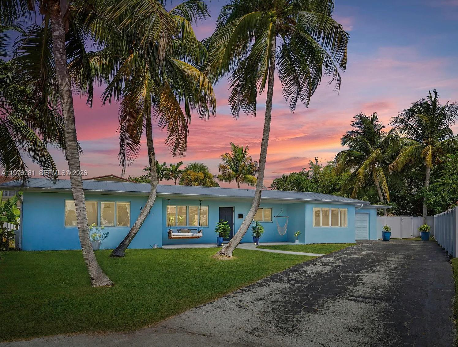 2211 Northeast 35th Court Lighthouse Point, FL 33064 - Photo 1 of 21 a front view of a house with a yard and palm tree