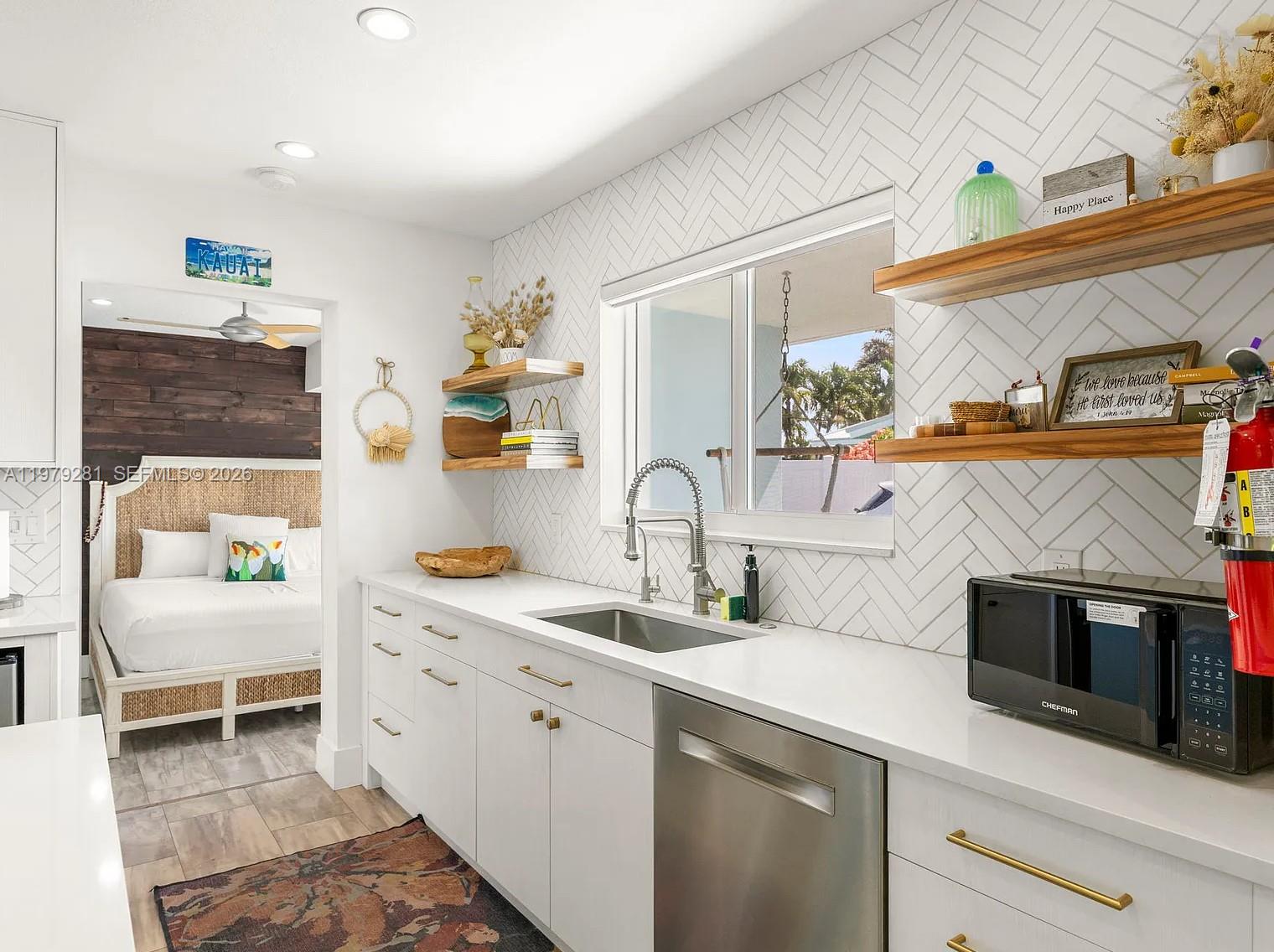 2211 Northeast 35th Court Lighthouse Point, FL 33064 - Photo 11 of 21 a kitchen that has a sink and a stove with wooden floor