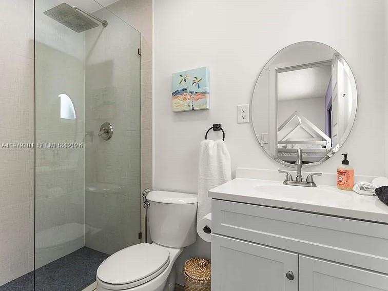 2211 Northeast 35th Court Lighthouse Point, FL 33064 - Photo 7 of 21 a bathroom with a sink a toilet and a mirror