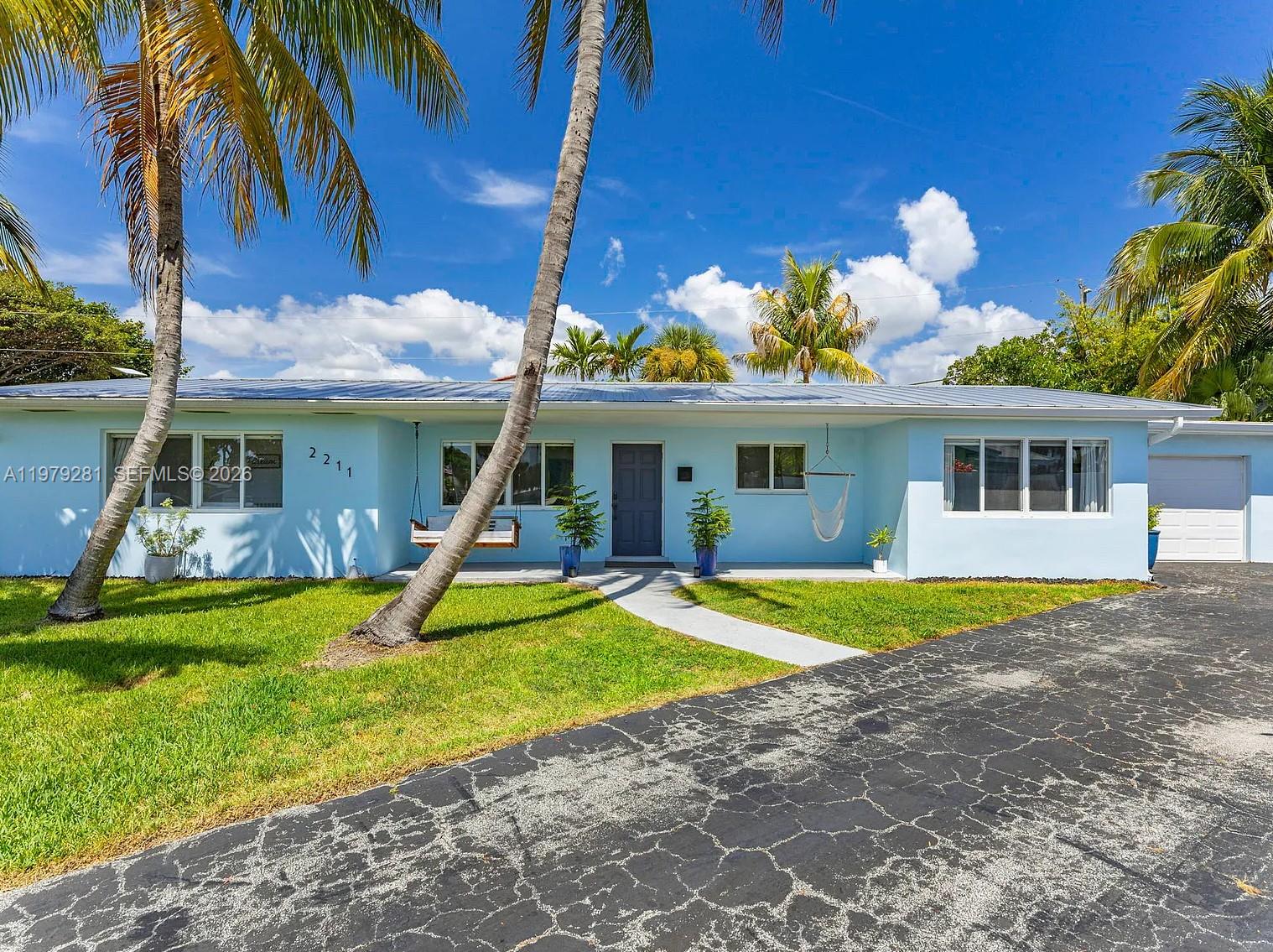 2211 Northeast 35th Court Lighthouse Point, FL 33064 - Photo 10 of 21 a view of a house with a backyard and a tree