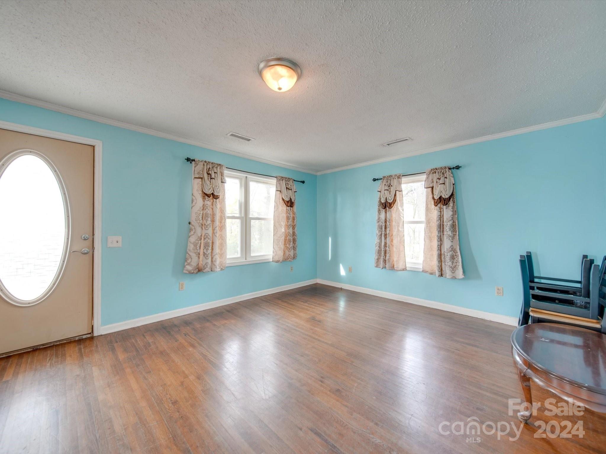 6362 Talley Road Stanfield, NC 28163 - Photo 4 of 39 an empty room with wooden floor and windows